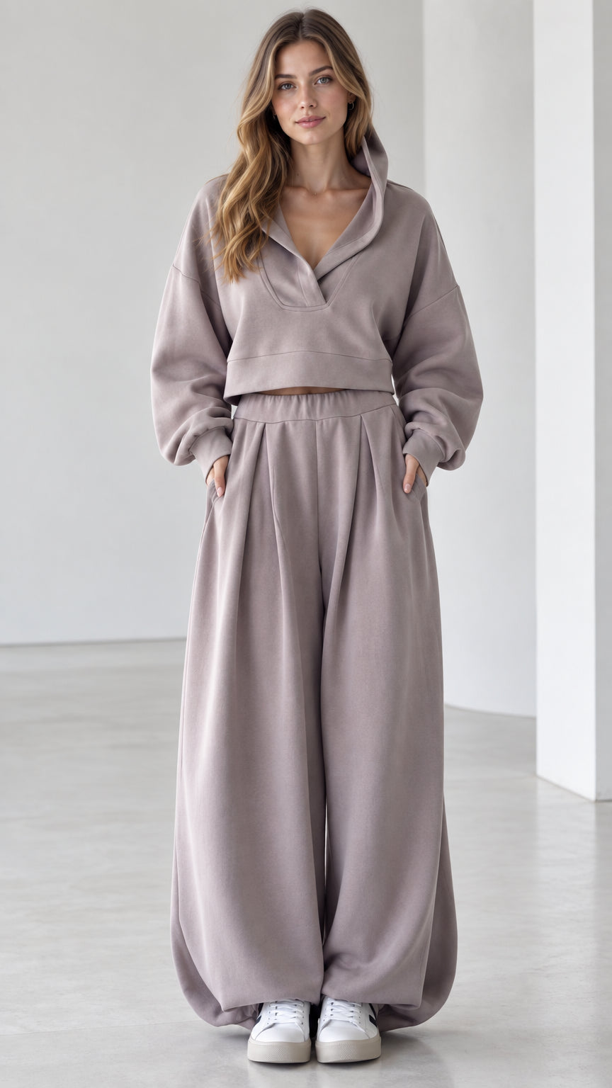 Front view of woman wearing mauve cropped V-neck hoodie and wide-leg pleated sweatpants lounge set