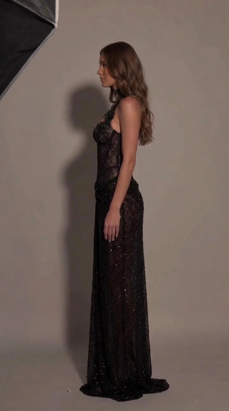 Side profile view of black sheer corset evening gown showing fitted silhouette
