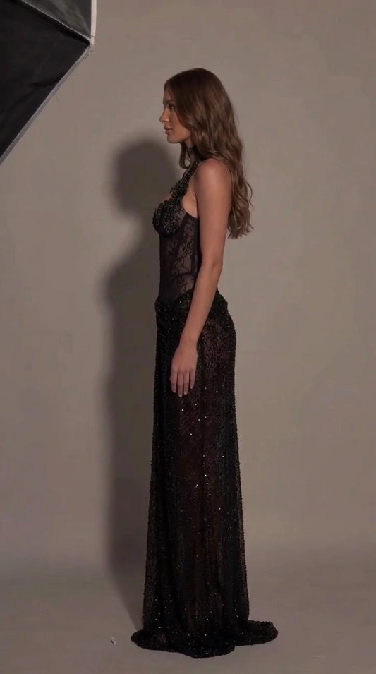 Side profile view of black sheer corset evening gown showing fitted silhouette