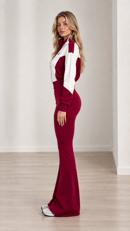 Side profile view of woman modeling burgundy colorblock bell-bottom jumpsuit