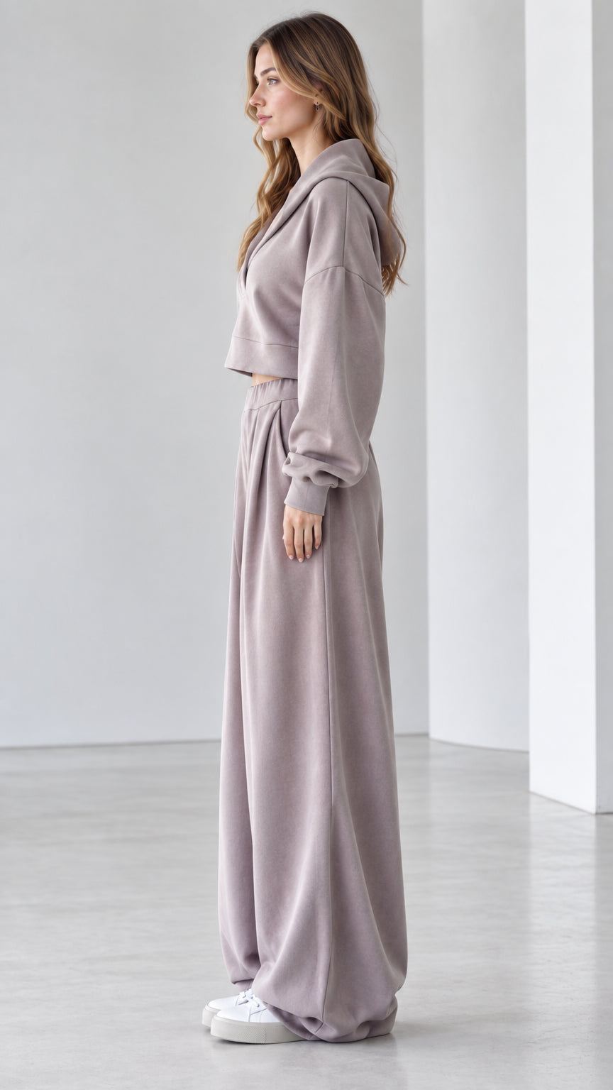 Side profile view of woman modeling mauve two-piece cropped hoodie and wide-leg pants set