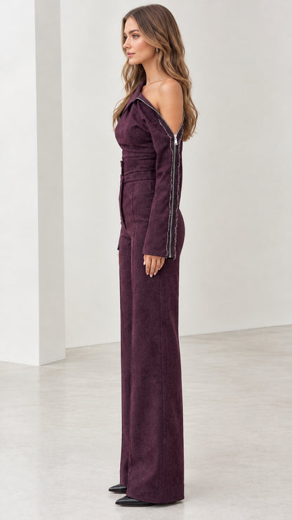 Side profile of model in tailored plum wide-leg jumpsuit with zipper detailing