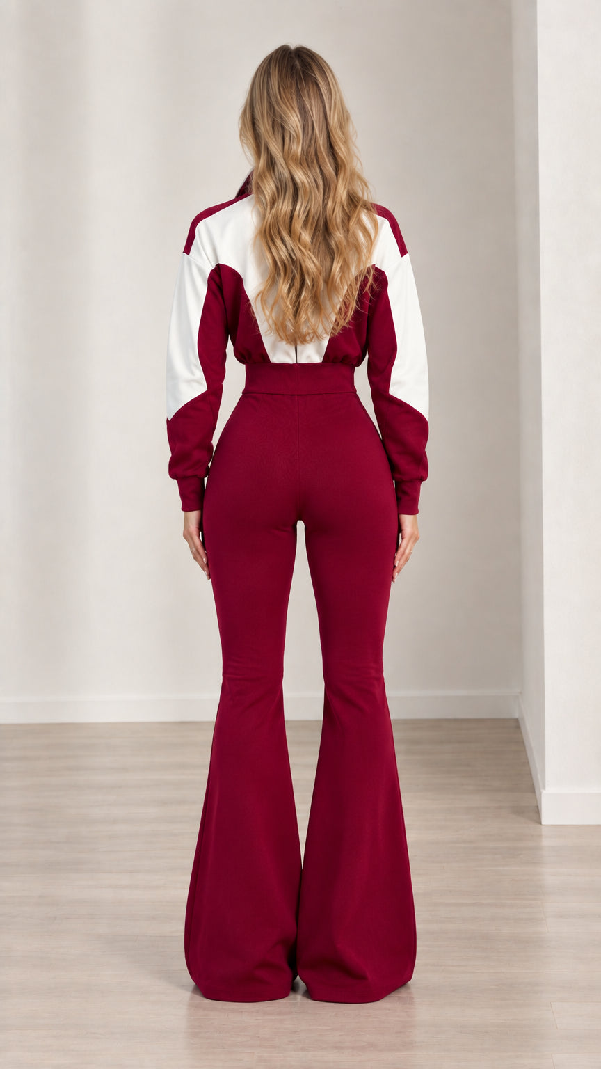 Back full-length view of woman in burgundy colorblock flare jumpsuit