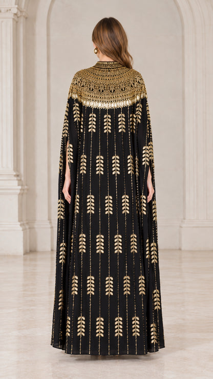 Back view of black floor length kaftan showing full cape drape and sequin pattern