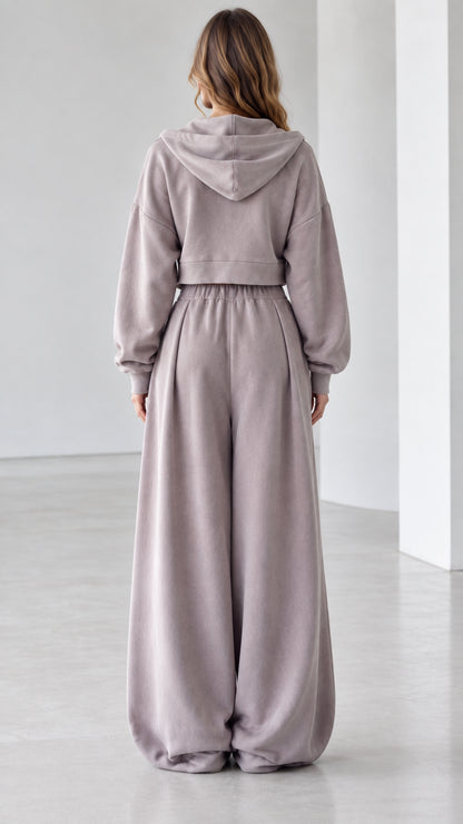 Back view of woman wearing mauve hooded sweatshirt and fluid wide-leg lounge pants