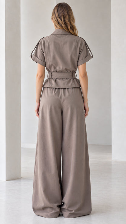 Back full-length view of taupe wide leg jumpsuit showing relaxed silhouette