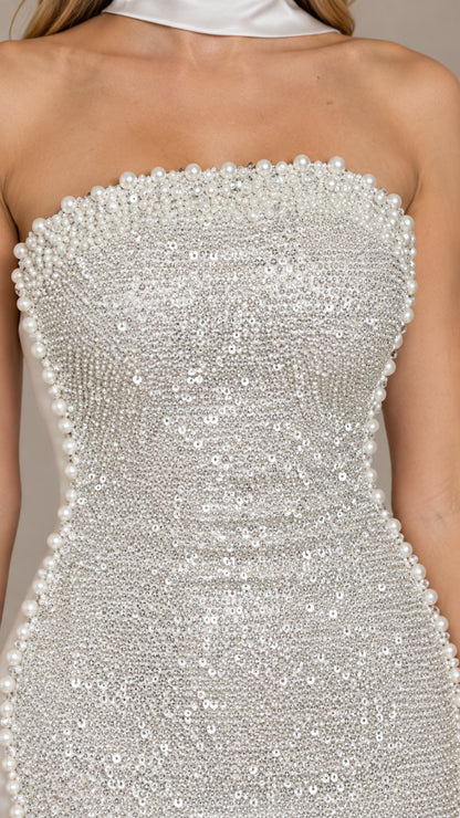 Close-up detail of silver sequin embellishments and lustrous pearl trim along the neckline and seam