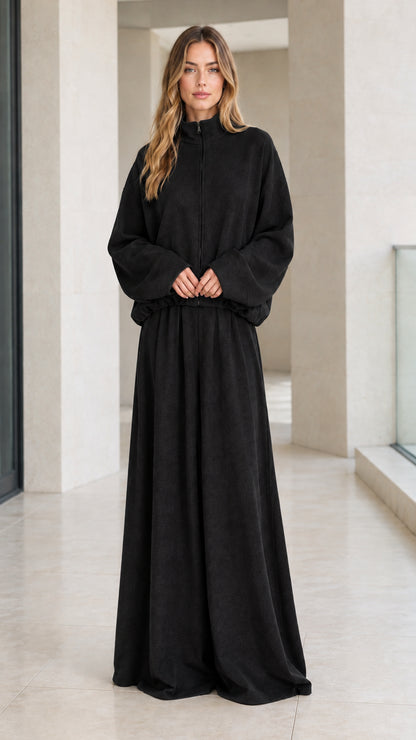 Front view of woman wearing solid black zip-up lounge jacket and matching wide-leg pants