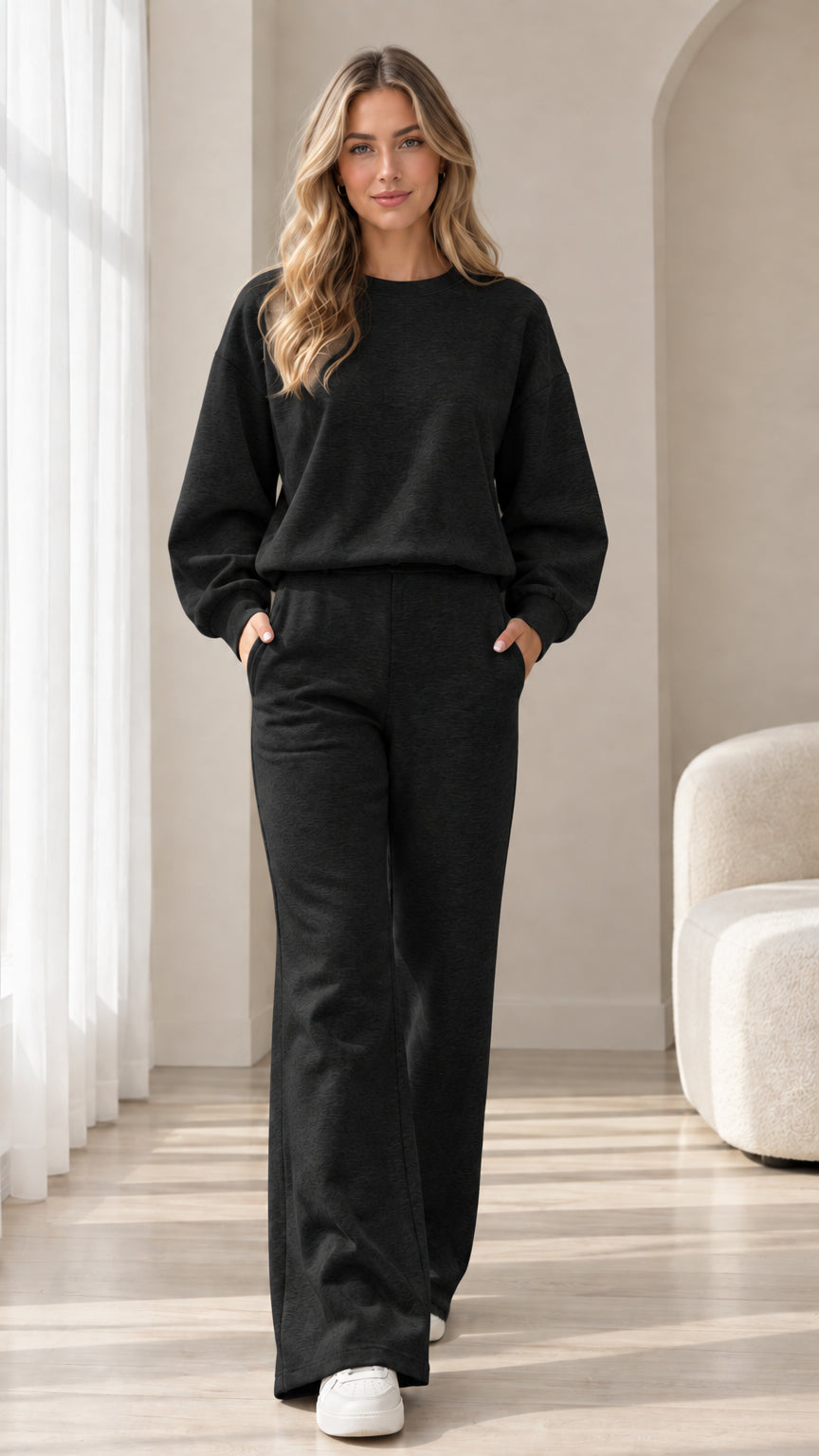 Front view of model wearing black 2-piece sweatshirt and wide leg sweatpants set