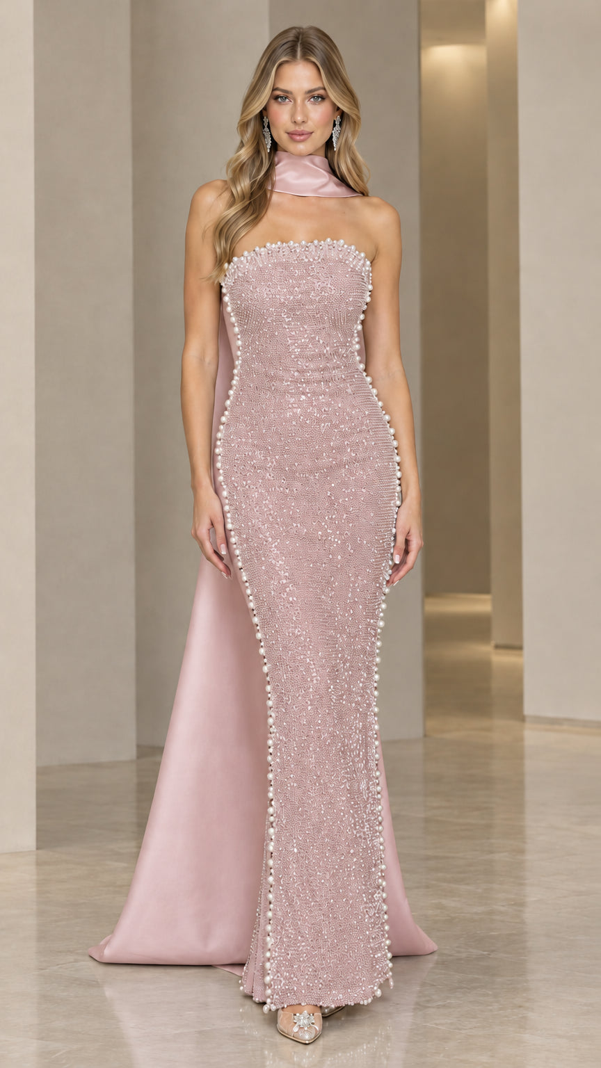Model wearing blush pink beaded column maxi dress with flowing pink scarf train