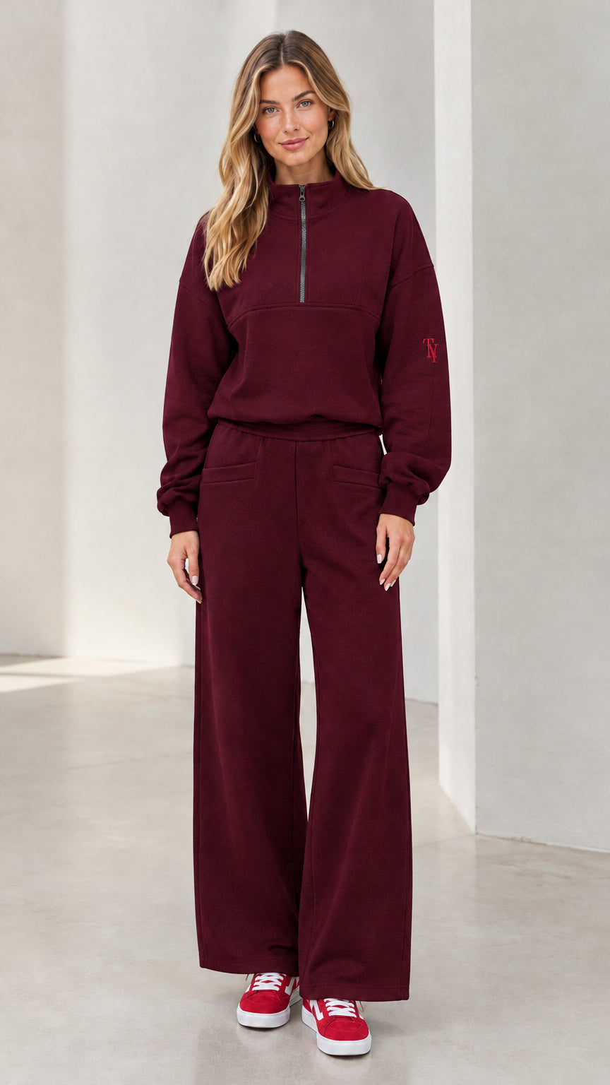 Front view of woman wearing burgundy half-zip pullover and wide-leg lounge set