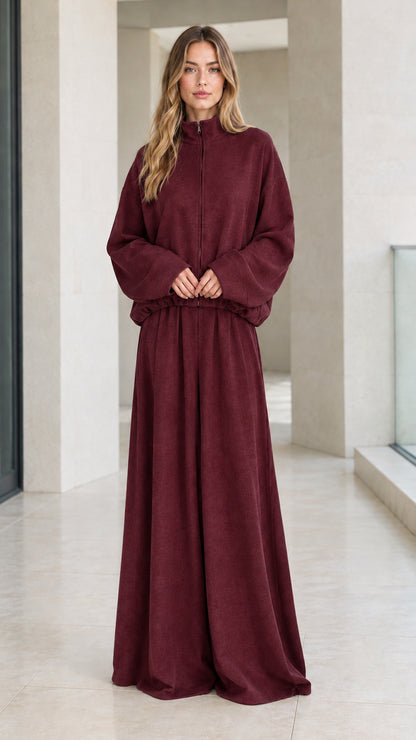 Front view of woman wearing deep burgundy zip jacket and wide-leg trouser set