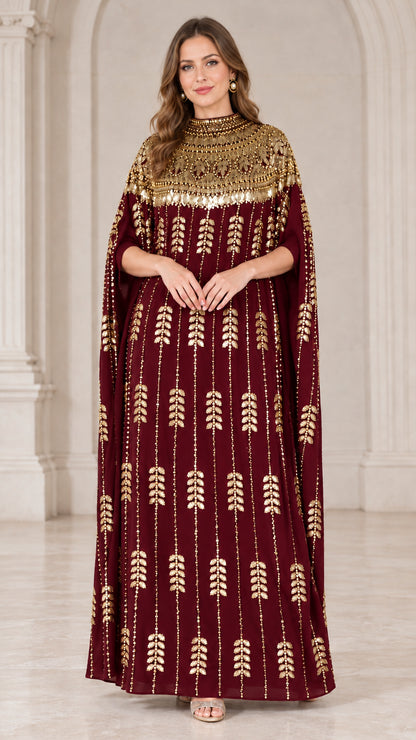 Burgundy kaftan evening gown with sparkling gold embellishments and cape sleeves